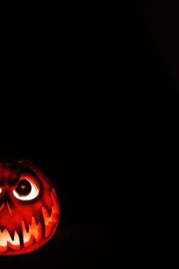 Korkunç Cadılar Bayramı balkabağı karanlık ortamda şeytani ışıkla parlıyor..