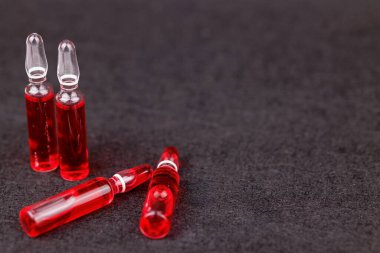 Siyah arkaplanda kırmızı B12 ampulleri canlılık ve tıbbi tedavi gösteriyor