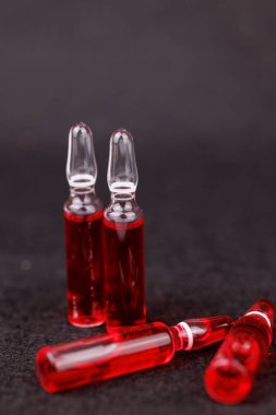 Kırmızı vitamin B12 enjeksiyon ampulleri koyu arkaplanda sağlığını ve tıbbı yansıtıyor