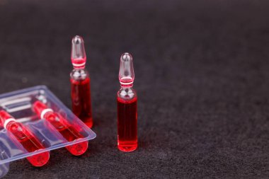 Siyah zemin üzerinde kırmızı B12 cam ampulleri terapi ve beslenme