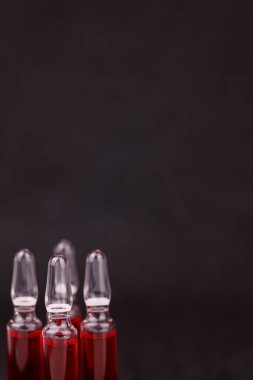 Koyu arkaplanda gösterilen kırmızı B12 ampulleri terapiyi simgeliyor