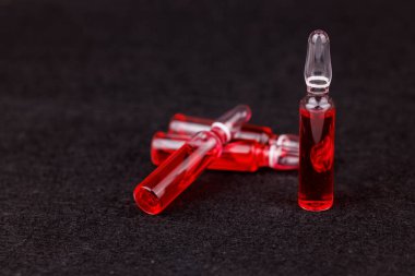 Sağlık için koyu arkaplanda kırmızı B12 ampullerinin düzenlenmesi