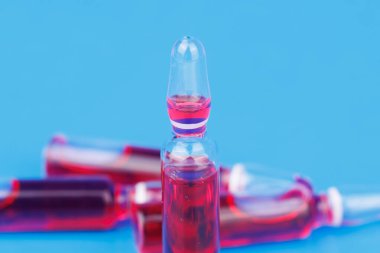 Sağlık desteği için mavi zemin üzerindeki kırmızı B12 cam ampullerini kapat