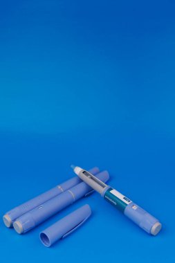 Healthcare composition with semaglutide pens, pill bottles, and vitamin B12 ampoules