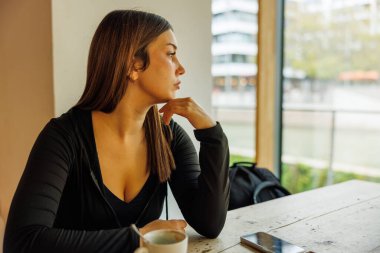 Büyüleyici bir kafede kahveyle rahatlayan genç bir kadın.