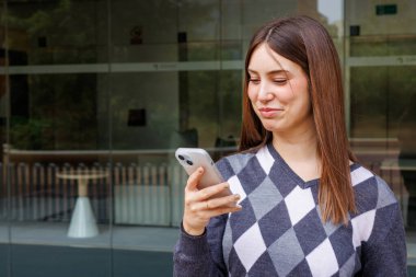 Parkta telefon ve kredi kartıyla online alışveriş yapan güzel bir kadın.