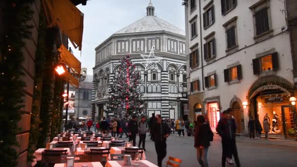 フィレンツェ 2019年12月 観光客はフィレンツェのドゥオーモ広場で買い物に行きます 背景にはクリスマスツリーと洗礼堂 イタリア — ストック動画