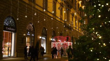 Floransa, Aralık 2019: Floransa 'nın merkezinde parlak ışıklar ve turistlerle Noel süslemesi. Tornabuoni yoluyla, Floransa 'nın tarihi merkezindeki moda sokağı. İtalya.