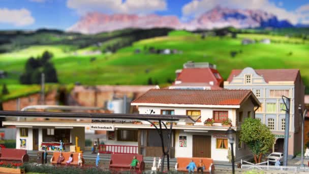 イタリア フィレンツェ2022年12月 ミニチュアの赤い模型おもちゃ列車が駅に到着 鉄道模型 山の環境 — ストック動画
