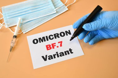 Covid-19 'un yeni versiyonu. Doktorun eli mavi eldivende ve beyaz çarşaf ve koruma maskelerine 