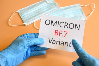 Covid-19 'un yeni versiyonu. Doktorun elleri mavi eldivende ve beyaz kağıda 