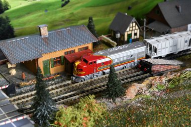 Florence, February 2023: Miniature freight train model arrive to Train Station. Model railway. Miniature model of train on a mountains ambientation. Railway modelling. Italy