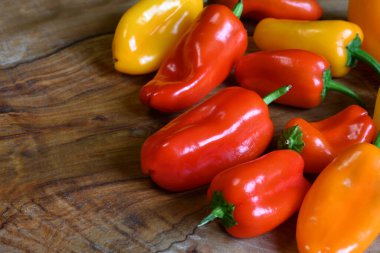 Close up on red and yellow peppers on wooden background