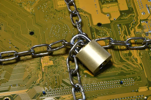 Iron chain and padlock on the printed circuit board. Cyber security concept.