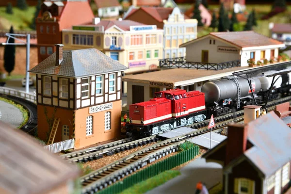 Miniature railway model with trains. Toy Train with wagons at Railway Station in a city.