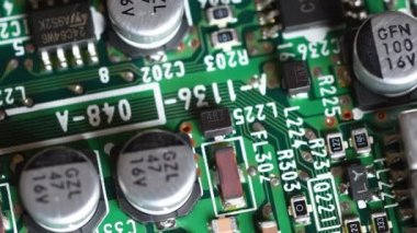 Dönüşümlü bileşenleri olan devre kartı. Elektronik bileşenleri olan yeşil elektronik panoya aşırı yakın çekim.