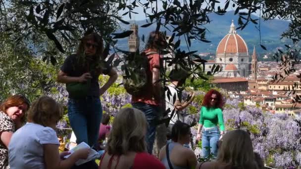 2023年4月 フィレンツェ 観光客はオリーブの木の下でリラックスし ミケランジェロ広場近くの美しいバルディーニ庭園からサンタ マリア フィオーレ大聖堂を賞賛します イタリア — ストック動画