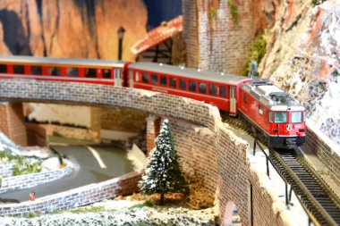 Floransa, İtalya - Mayıs 2022: İsviçre Bernina Ekspres Treni ile demiryolu modeli kış mevsiminde dağlarda viyadük üzerinde.