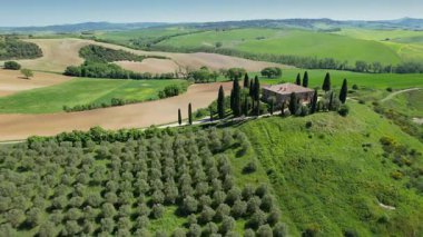 İlkbaharda Toskana 'daki bir çiftlik evinin etrafındaki Val d' Orcia tepelerinin hava manzarası. San Quirico, İtalya.