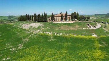 İlkbaharda Toskana 'daki bir çiftlik evinin etrafındaki Val d' Orcia tepelerinin hava manzarası. San Quirico, İtalya.