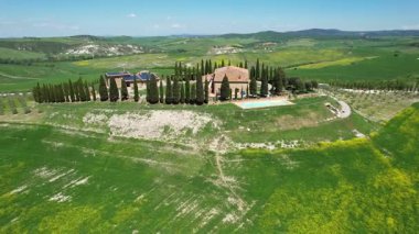 İlkbaharda Toskana 'daki bir çiftlik evinin etrafındaki Val d' Orcia tepelerinin hava manzarası. San Quirico, İtalya.
