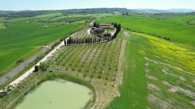 İlkbaharda Toskana 'daki bir çiftlik evinin etrafındaki Val d' Orcia tepelerinin hava manzarası. San Quirico, İtalya.