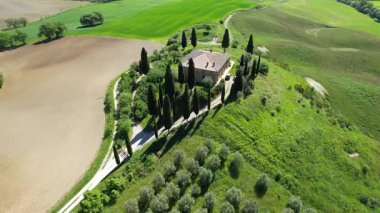 İlkbaharda Toskana 'daki bir çiftlik evinin etrafındaki Val d' Orcia tepelerinin hava manzarası. San Quirico, İtalya.