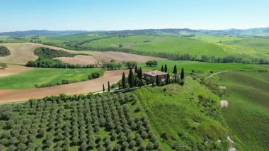 İlkbaharda Toskana 'daki bir çiftlik evinin etrafındaki Val d' Orcia tepelerinin hava manzarası. San Quirico, İtalya.