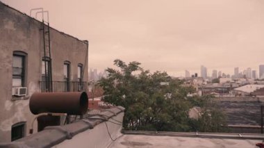 Eski apartman ve endüstriyel baca ile New York şehrinin kısmi manzarası.