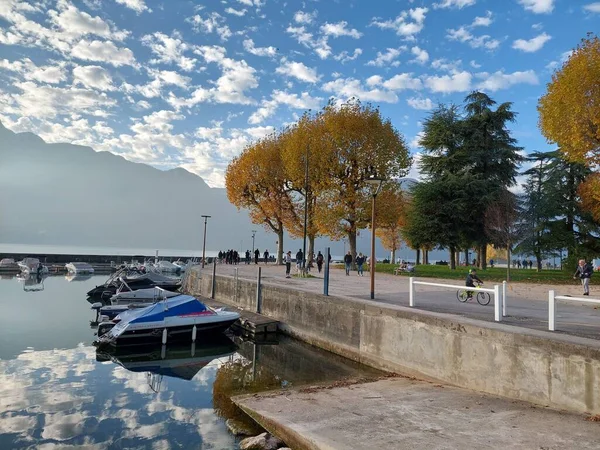 Aix les bains 'in küçük limanında birkaç tekne, Savoy, Fransa. Ağaçlardaki sonbahar renkleri ve göldeki güzel bulutlar