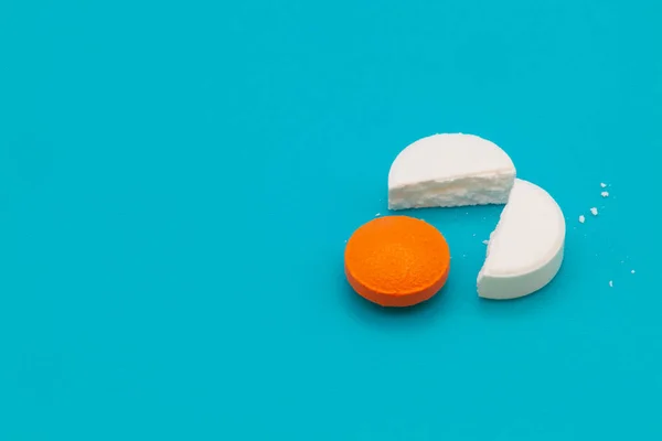 Tıbbi ilaçlar ve kapsüller masada. Mavi zemin üzerinde haplar ve metin için boşluk