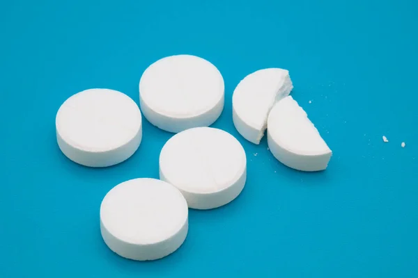 Tıbbi ilaçlar ve kapsüller masada. Mavi zemin üzerinde haplar ve metin için boşluk