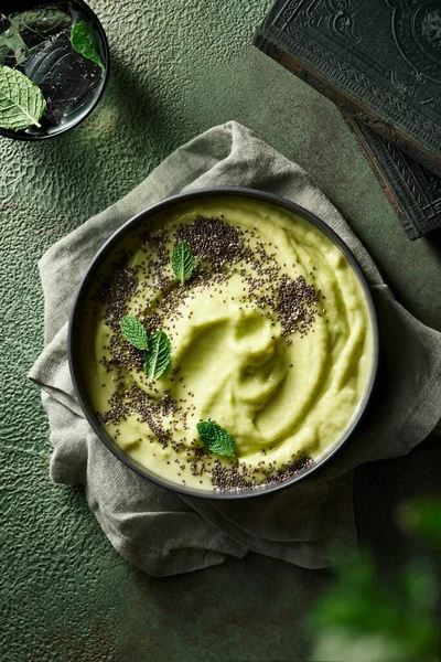 Çim çekirdeği ve nane ile kaplı yeşil pürüzsüz kase. Tüm renklerle tek renkli görüntü. 