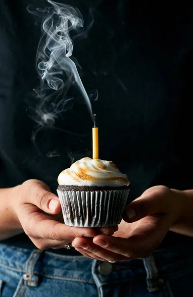 Mini çikolatalı kek, üzerine pembe jöle dökülüyor kaşıktan. Sahnenin arkasında bir şahıs var. Koyu gri arka plan ve siyah taş masa. Bir insan elementi ile yaşam tarzı dikey görüntü.