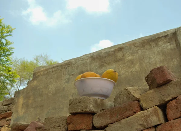 Hasır sepeti ve lezzetli mangolarla dolu bir adam. Sarı Mango 'nun yakın çekimi. Olgunlaşmış sarı mangolarla dolu bir sepet. Taze olgun mangolar sepetin içinde. Asya mangosu.