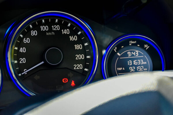 Mileage distance on the car dashboard digital speedometer car blue light with a red warning light in the car.