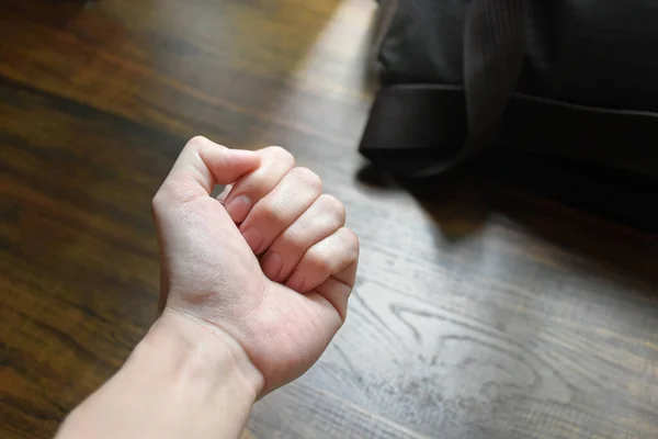 机の手のひら柔らかい日光および仕事袋の背景 テーブルの手 怒りを伝える手 決意を示す手 仕事の圧力 木のパターン ワーク テーブル 黒い仕事袋 — ストック写真