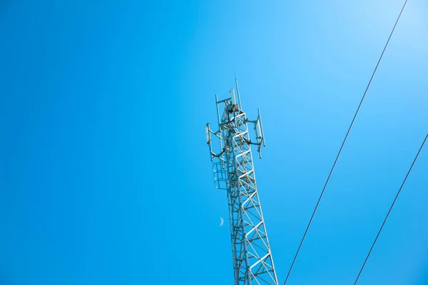 Anten telekomünikasyon ve Ay 'daki kablo ve açık gökyüzü arkaplanı, gün doğumuyla güzel gökyüzü ve bulutlar, iletişim ve veri iletimi kavramı, gelecek 5G kablosuz, aşağıdan görüntü.