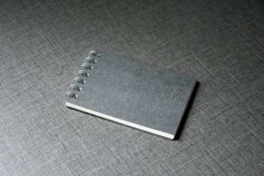 Koyu tablo ahşap şablon arkaplan üzerine Siyah Boş Not Defteri, tasarım için kopyalama alanı olan boş siyah kapak şablonu, koyu arkaplanda izole edilmiş not defteri, tasarım ve iş konsepti.