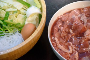 Izgara domuz konsepti için Tayland Yakiniku usulü Kore barbekü büfesinde barbekü malzemesi olarak kullanılan bir kasede yumurta ve marine edilmiş etle çeşitli sebzeler Moo Kra ta 'dır..