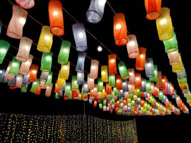 Dekoratif ışıklar ve renkli fenerler gece festival için renkli kağıtlardan yapılır veya koyu siyah arka plandaki mekan dekorasyonu için.