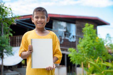 Asyalı genç adam sarı bir tişört giymişti ve elinde beyaz bir tabela tutuyordu. Elinde yeşil bir arka plan vardı..