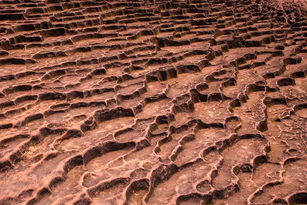 stock image The geological phenomenon of lava rocks and the movement of brown rocks creates holes and ponds that are natural reservoirs for water. The surface of the stone has an amazing shape.