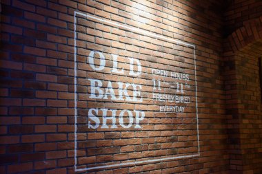 Vintage brick wall of a bakery and white letters the word old bake shop, Brown brick wall background with empty space. clipart