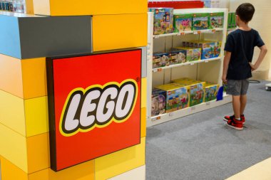 PATTAYA, THAILAND - 28 Nisan 2024: Lego mağazasındaki lego oyuncaklarına bakan çocuk. LEGO logosu ve plastik inşaat oyuncakları raflarının kapatılması mağazalarda duruyordu..