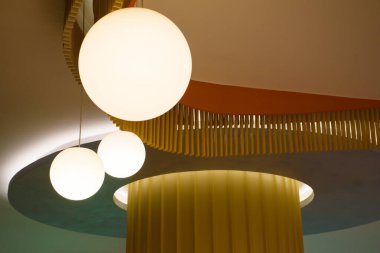 Modern güzel tavan ışığı. Modern evdeki kahverengi duvarlı lambalar dizisi, minimalist iç dekorasyonu 2024 'ün sıcak tonlarında dairesel ampullerle süslenmiş.. 