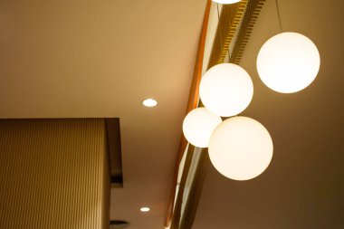 İçinde modern ev tarzında kahverengi bir duvar olan lambalar seti, modern güzel tavan lambasının manzarası. Minimalist iç mekan 2024 'ün sıcak tonlarında dairesel ampullerle süslenmiştir..