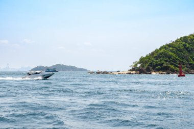 Mavi deniz ve açık mavi gökyüzü arka planındaki Koh Larn adasında adanın manzarası ve tropikal plaj sabahı. Pattaya, Tayland. Dalga, sürat teknesi, feribot, deniz manzarası, tatil, yaz, tatil.