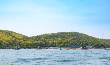 Adanın arka planındaki mavi tropikal denizde tekne gezintisi ve Koh Larn adasındaki tropikal plaj sabahı. Körfezde çalışan feribot gemisi, Panorama Okyanusu, Pattaya, Tayland, Tatil.