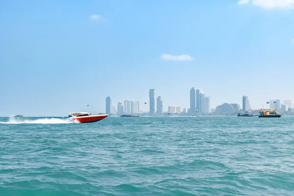 Pattaya şehir manzarasının arka planında mavi tropikal denizde yüzen sürat teknesi ve Koh Larn adasında açık bir gökyüzü sabahı. Körfezde sürat teknesi, Panorama Okyanusu, Tayland, Tatil.